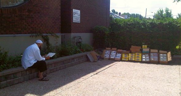 12 - Vendor reads Qur'an beside his merchandise, before Jumah Prayers, Ottawa Main Mosque, Jumah Friday August 2 2013